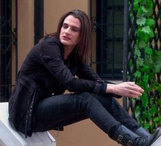 a man sitting on top of a white bench