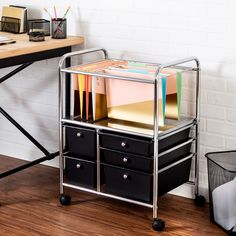 a metal cart with file folders on top of it next to a wooden desk