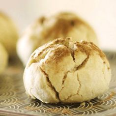 some bread is sitting on a plate with other food items in the backround