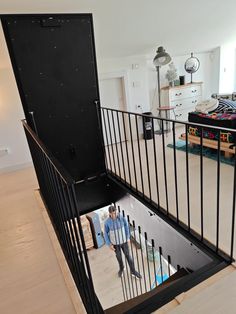 a man is walking up the stairs in his house with an open door to another room