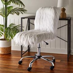 an office chair with white fur on it in front of a potted palm tree