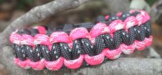 a pink and black bracelet on a tree branch