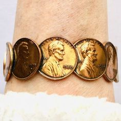 a woman's wrist with three gold coins on it and one coin in the middle