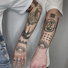 two people with tattoos on their arms and hands, both holding each other's hand