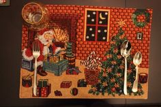 a needled christmas scene with santa and his kitchen utensils hanging on the wall