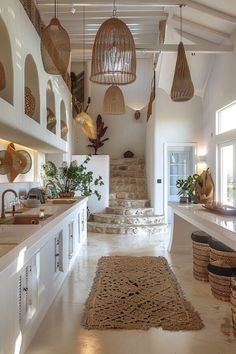 a kitchen with white walls and flooring has baskets hanging from the ceiling over the counter