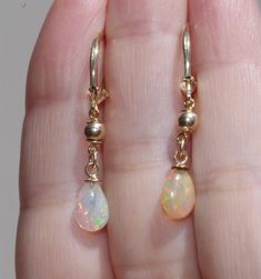 14k gold fiery ethiopian opal elongated lever back earrings ccc fiery ethiopian opal drop lever backs a quality ethiopian opal 7.5 ctw total length of tear drops including bail on avarage: 11- 12mm diameter of round gold balls: 4 mm from top to bottom 35 mm diameter of opals: 7 x12 mm in widest area nice size opal drops Ethereal Earrings, Pearl Earring Jacket, Mermaid Board, Ethereal Jewelry, Pretty Accessories, Tear Drops, Ear Ring, Thread Earrings, Leverback Earrings