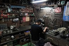 a man working in a shop with lots of tools