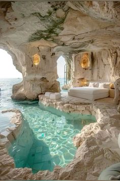 an indoor swimming pool surrounded by rock formations