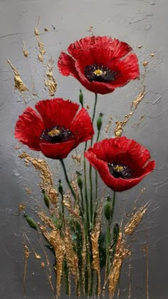 three red flowers in a vase with gold flakes