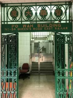 an entrance to a building with iron gates and writing on the front door that says p o wah building no 54 queen's road