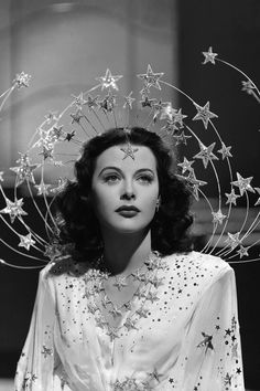 a black and white photo of a woman with stars on her head