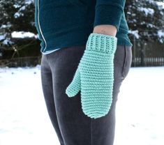 a woman wearing a green knitted mitt in the snow