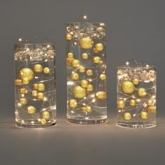 three glass vases with lights in them