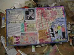 an open book with pictures and writing on it, surrounded by other items such as paint