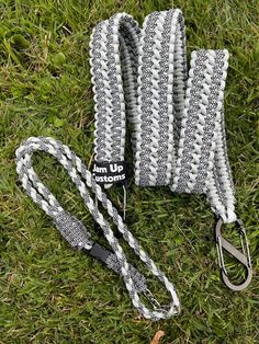 two lanyards are laying on the grass and one has a leash attached to it