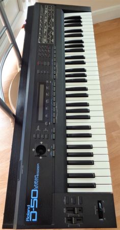 an electronic keyboard sitting on top of a hard wood floor