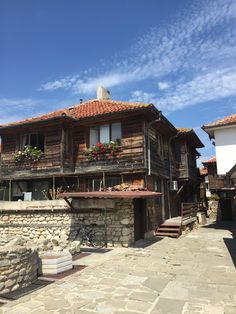 an old wooden house with flowers on the balcony