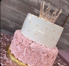 a pink and gold cake with a crown on top