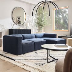 a living room filled with furniture and a round mirror