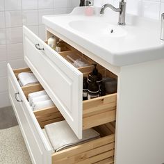 an open drawer in a bathroom next to a sink