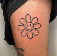 a man with a tattoo on his leg that has a smiley face in the middle