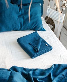 a bed with blue sheets and pillows on it