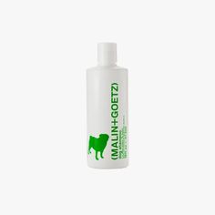 a bottle of dog grooming lotion on a white background with a green logo