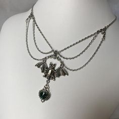 This gothic vampire inspired necklace is made with an antiqued silver plated bat. filigrees and findings, accented with sparkling glass crystals in EMERALD GREEN. Decorated portion is 6" wide and centerpiece is 2 7/8" tall in the center.Necklace is adjustable 15-18" with a lobster clasp and chain extender in the back. If you would like a different length or stone color, please send us a message. Silver Vampire Style Necklace, Gothic Nickel-free Necklace For Halloween, Gothic Nickel-free Necklaces For Halloween, Nickel-free Gothic Necklaces For Party, Silver Vampire Style Metal Jewelry, Silver Vampire Costume Jewelry, Gothic Metal Necklace, Silver Vampire Style Costume Jewelry, Silver Fantasy Necklace For Halloween