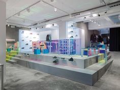 the inside of a retail store with colorful display cases and shoes on shelves in front of them