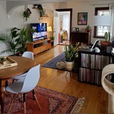 a living room filled with furniture and a flat screen tv sitting on top of a wooden table