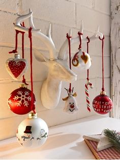 christmas ornaments hanging from hooks on the wall