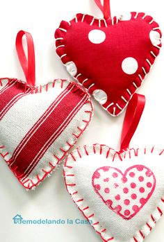 three heart shaped ornaments are hanging on a white tablecloth with red and white polka dots