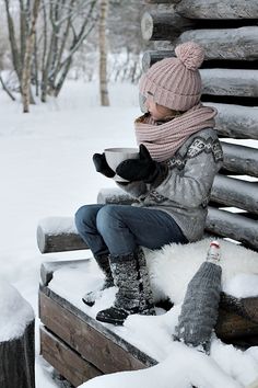 a person sitting on a bench in the snow