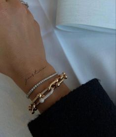 a woman's arm with two bracelets on it