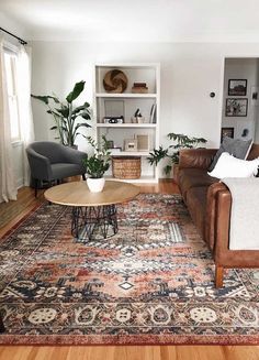 a living room filled with furniture and a rug on the floor in front of a window