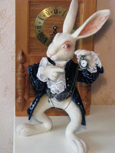 a white rabbit dressed up as a gentleman in front of a wall clock with the time on it's face