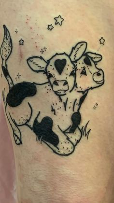 a black and white tattoo of a cow with stars on it's back leg