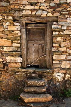 an old wooden door with stone steps leading up to it