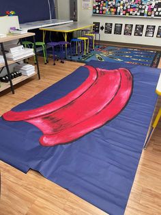 a blue mat with a red hat on it in the middle of a school room