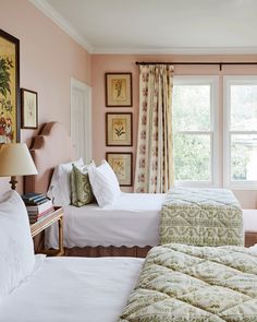 two beds in a bedroom with pink walls