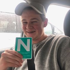 a man sitting in the back seat of a car holding up a sign