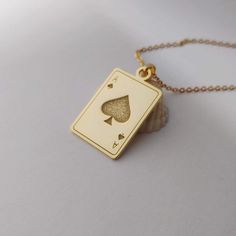 "Our personalized Playing Card Necklace is a true masterpiece, featuring a carefully designed pendant that captures the essence of your favorite card suit. The charm is customized to your specifications, ensuring a one-of-a-kind piece that reflects your personal style and passion for card games. This poker pendant is made of 925 STERLING SILVER, and you also have the option to choose 18k gold plating, rose gold plating, or platinum plating over the 925 sterling silver. It measures about 25 mm(1 inch) and is 1.2mm thick. The length of the sterling silver chain can be selected from 14\",16\",18\",20\" or 22\".  How To Order Please let me know let me know the card you'd like in the note. The item will arrive in a jewelry gift box. Please let me know if you want to include a handwriting messag Cards Necklace, Card Necklace, Playing Card, Necklace Personalized, Bar Necklace, Jewelry Gift Box, Deck Of Cards, Gold Plating, Sterling Silver Chains