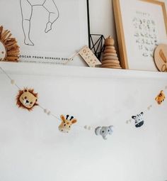 a baby crib with stuffed animals hanging from it's sides and pictures on the wall