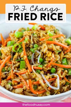 a bowl filled with fried rice and carrots on top of a red and white table cloth