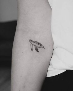 a small turtle tattoo on the left arm