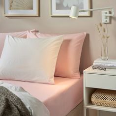 a bed with white sheets and pillows in a bedroom