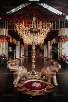 an elephant statue sitting on top of a wooden table next to a chandelier