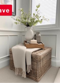 a wicker basket with towels and vase on it