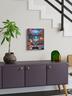 a painting is hanging on the wall next to a purple cabinet with a potted plant